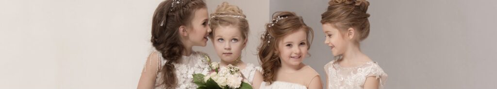 Bambine vestite in abiti da sposa con un bouquet di fiori in mano