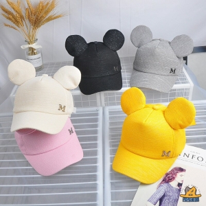 Cappellino estivo per bambini alla moda in una gamma di colori su un tavolo con un vaso