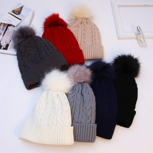 Cappello invernale alla moda per le ragazze, diversi colori su un tavolo