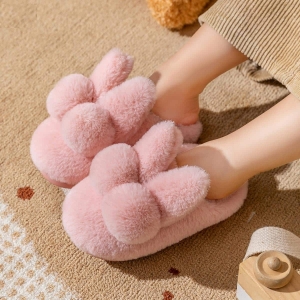 Morbide pantofole a forma di coniglio di peluche rosa, indossate da una bambina