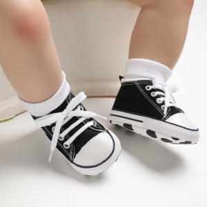 Scarpe da ginnastica alte nere con lacci indossate da un bambino
