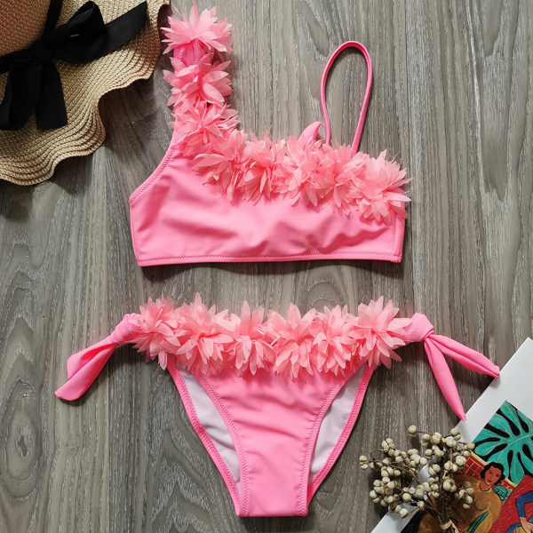 Set di bikini rosa a 2 pezzi per ragazze alla moda su un tavolo
