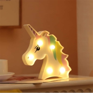 Luce notturna a LED a forma di unicorno per la camera da letto di una bambina su un tavolo in una casa