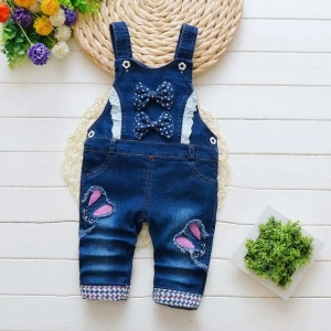 Tuta in denim alla moda per le bambine su un tavolo
