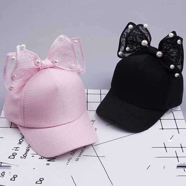 Cappello con papillon nero e rosa delle ragazze sul tavolo