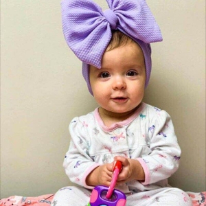 Cappello a turbante viola alla moda per le bambine, indossato da una bambina