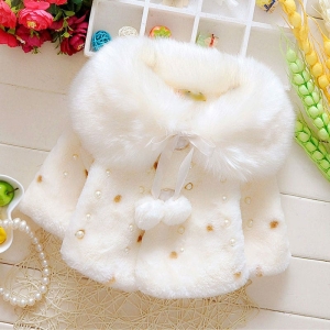 Cappotto invernale in pelliccia sintetica bianca per ragazze su un tavolo