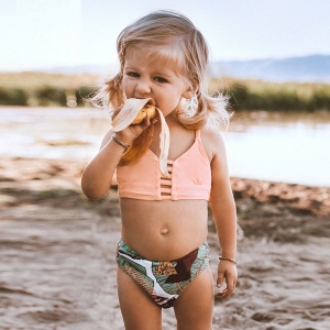 Costume da bagno a 2 pezzi per bambina, indossato da una bambina in spiaggia.