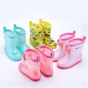 quattro paia di stivali da pioggia per bambini sono posizionati su uno sfondo bianco. Gli stivali sono blu, gialli, rosa e viola