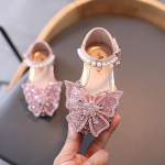 Sandali estivi con paillettes per le bambine su una sedia