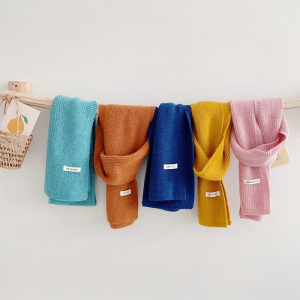 cinque sciarpe appese ad una corda, una accanto all'altra, la prima azzurra, la seconda arancione, la terza blu scuro, la quarta gialla e l'ultima rosa