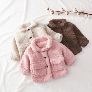 Un caldo cappotto di pelliccia nei colori rosa, beige e marrone per i bambini, sovrapposto a un ramo con fiori bianchi