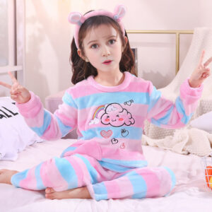 Pigiama in pile con motivi di cuoro e nuvole per bambine indossato da una bambina in una casa