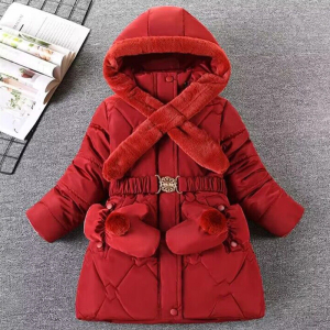 Giacca rossa da ragazza con cappuccio, adagiata su un pavimento grigio con accanto una rivista aperta