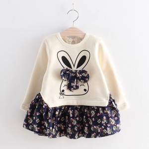 Vestito per bambina presentato su una gruccia, la parte superiore è beige con una simpatica testa di animale con fiocco e la parte inferiore è blu scuro