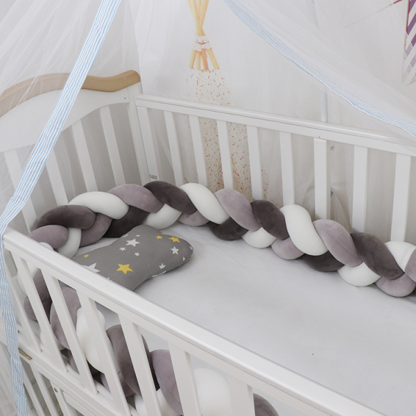 Paracolpi intrecciato grigio e bianco per la culla della bambina
