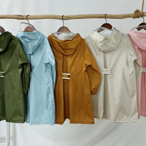 5 giacche a vento di colori diversi su una rastrelliera di legno