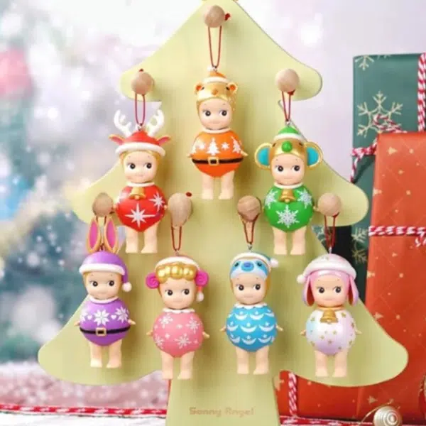 7 statuette Sonny Angel appese a un albero di Natale beige, con uno sfondo decorato in stile natalizio