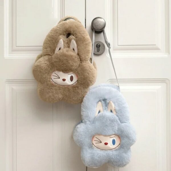 main_images__5-Photoroom.jpg due piccole borsette morbide a forma di fiore, con faccina di Labubu che fa l’occhiolino e grandi orecchie da coniglio. Una azzurra e una marrone chiaro appese a una maniglia