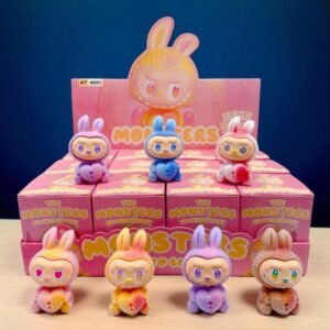 7 mini figure stile mostri Labubu di diversi colori, sedute e con un cuore con serratura tra le mani, appoggiate sulle loro scatole, su un bancone in legno con sfondo scuro.