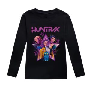 T-shirt per bambina K-pop Demon Hunters a maniche lunghe con motivo colorato. La t-shirt è nera. Il motivo mette in risalto le tre eroine del film con il nome del loro gruppo sopra in lettere maiuscole viola "HUNTRIX". Su sfondo bianco.